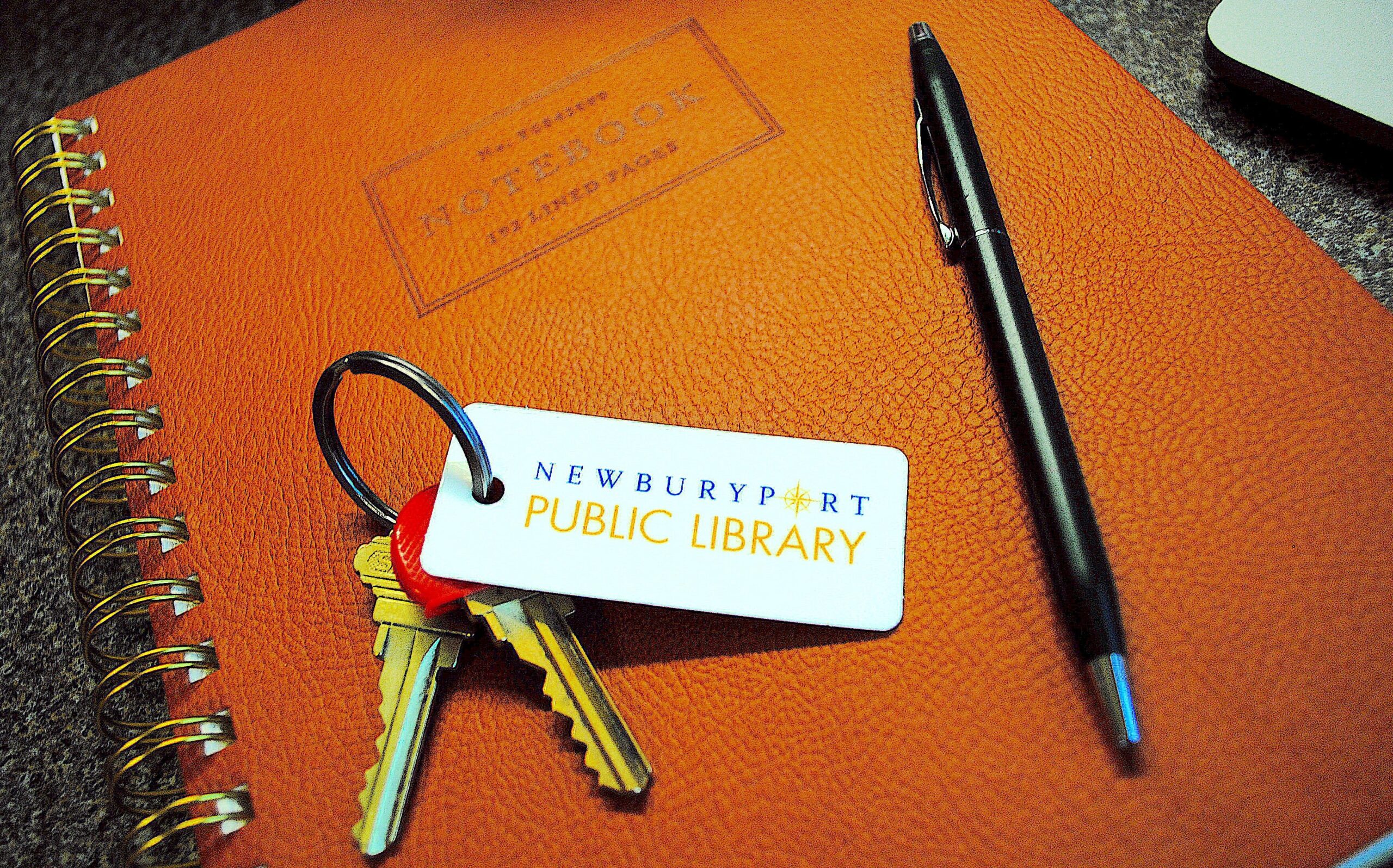 Library card on keyring with a pen on a notebook